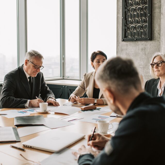 Executives working through documents around a boardroom table